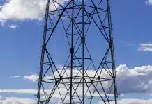 a tall metal tower sitting on top of a lush green field