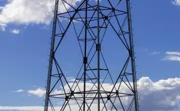 a tall metal tower sitting on top of a lush green field