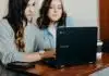 two woman using laptop